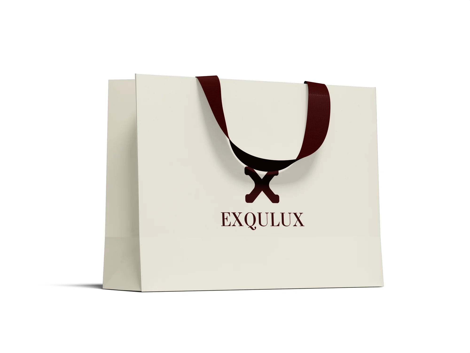 Eye-level product shot of the Exqulux paper bag — ribbon handle draped forward with the "X" mark reading through the fold
